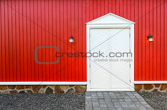 Red wooden wall and white front doors with two lamps
