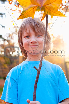 Portrait of a Boy Holding a Brown Leaf 