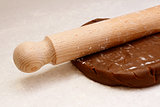 Closeup of rolling pin on gingerbread biscuit dough