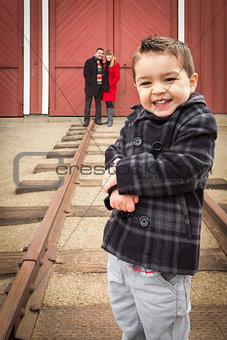 Mixed Race Boy at Train Depot with Parents Smiling Behind