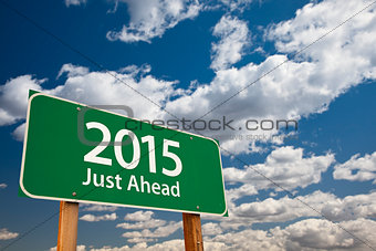 2015 Just Ahead Green Road Sign Over Clouds and Sky