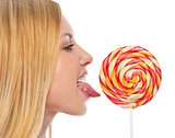 Profile portrait of teenage girl licking lollypop