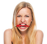 Teenage girl with red chili pepper in mouth