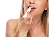 Closeup on happy teenage girl applying hygienic lipstick