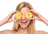 Portrait of happy teenage girl holding lemon in front of eyes