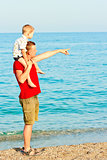 Father showing something to his son in the sea