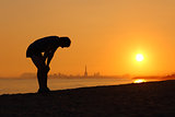 Silhouette of an tired sportsman at sunset