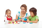 Woman and kids playing with colorful clay