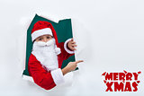 Santa popping out from hole and pointing to copy space