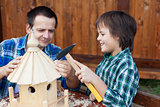 Father and son building a bird house or feeder