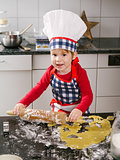 Happy young boy making cookies