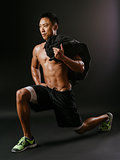 Man doing lunge exercises with sand bag