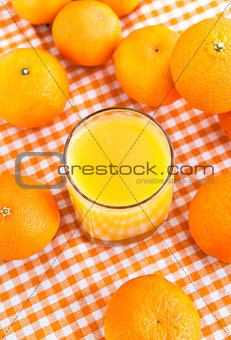 Glass of orange juice with some tangerines