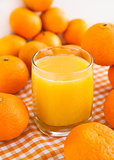Glass of orange juice with some tangerines 
