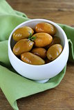 green marinated olives in a white bowl