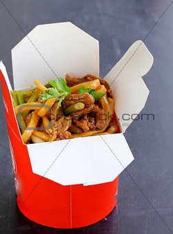 Chinese noodles with vegetables and meat in cardboard box