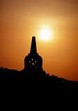 Decorative Buddhist stupa. Silhouette at sunset.