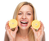 Portrait of happy teenage girl showing lemon slices
