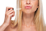 Closeup on teenage girl applying lip gloss