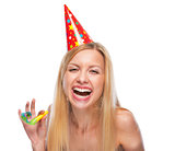 Portrait of happy teenage girl in cap with party horn blower