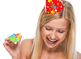 Portrait of smiling teenage girl in cap with party horn blower