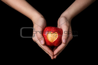 female teen hands holding apple with carved heart