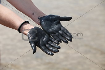 hands in black mud