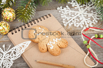 Christmas fir tree, decor and blank notepad on wooden board back