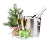 Christmas champagne bottle in bucket, glasses and fir tree