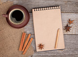 Blank notepad with coffee cup and spices on wooden table