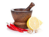 Mortar and pestle with red hot chili pepper and lemon