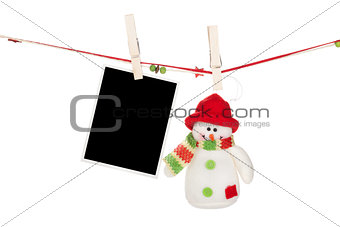 Blank photo frame and snowman hanging on the clothesline