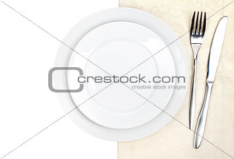 Silverware or flatware set of fork, knife and plate on towel