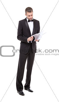 Man in a tuxedo reading the document