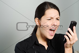 Woman screaming while looking at her mobile phone
