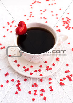 White cup of coffee decorated with red heart
