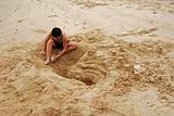children buildign sand castle at the beach