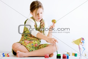 Young girl playing with paint and eggs