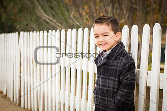 Young Mixed Race Boy Waiting For Schoold Bus Along Fence Outside