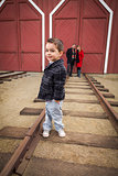 Mixed Race Boy at Train Depot with Parents Smiling Behind