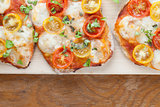 Mini pizzas with mozzarella, cherry tomatoes and basil