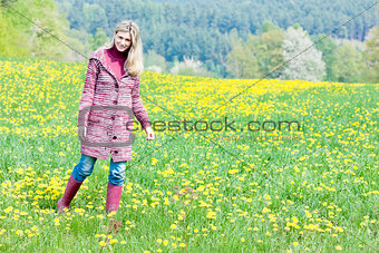 woman wearing rubber boots standing on spring meadow