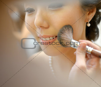 Asian bride applying wedding make-up