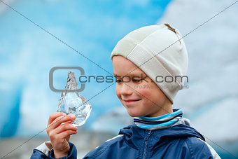 Boy with ice piece near Nigardsbreen glacier (Norway)