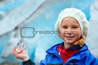 Girl with ice piece near Nigardsbreen glacier (Norway)