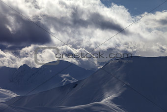 Off piste slope in sunlight clouds at evening