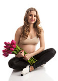 Happy young pregnant woman holding flowers