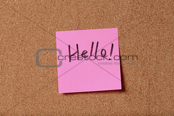 pink reminder sticky note on cork board
