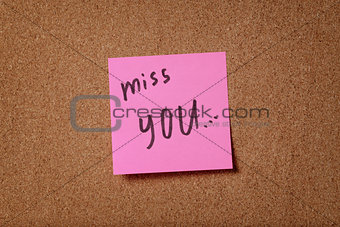 pink reminder sticky note on cork board