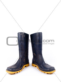 Pair of dark blue dirty rubber boots over a white background